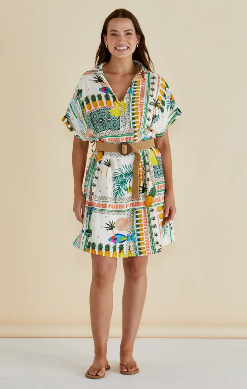 Woman wearing a colorful patterned dress against a beige background